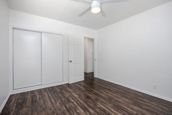 an empty room with white walls and a ceiling fan