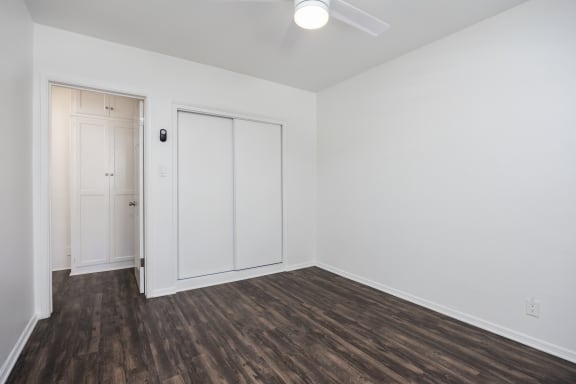 an empty living room with white walls and wood flooring