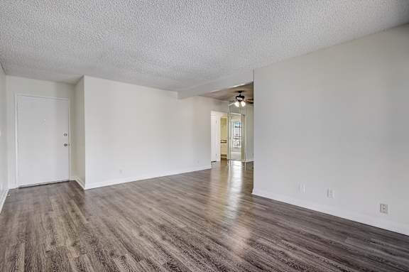 an empty living room with white walls and wood flooring
