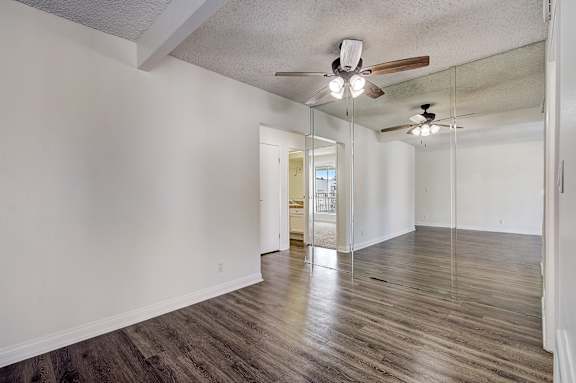 an empty living room with white walls and a ceiling fan