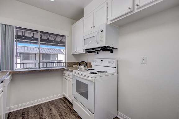 a kitchen with white appliances and a window