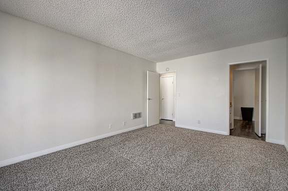 an empty living room with white walls and carpet