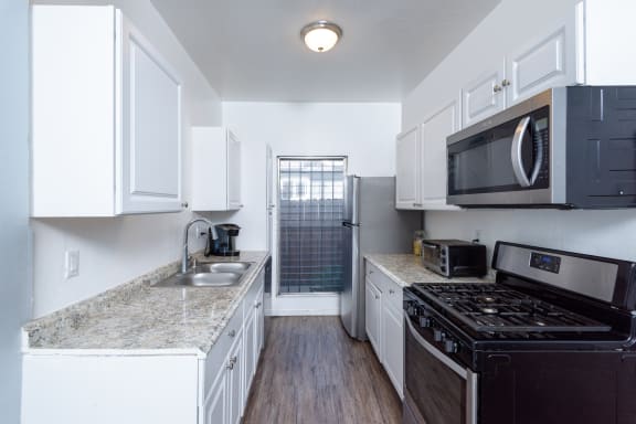 a kitchen with white cabinets and black appliances and a black stove