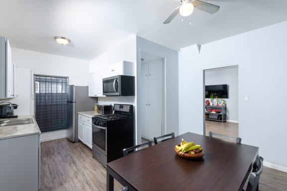 a kitchen and dining room with a wooden table and a black and white kitchen