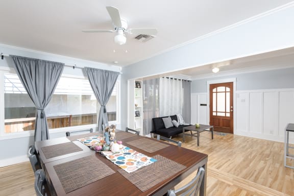 a dining room with a wooden table and a ceiling fan
