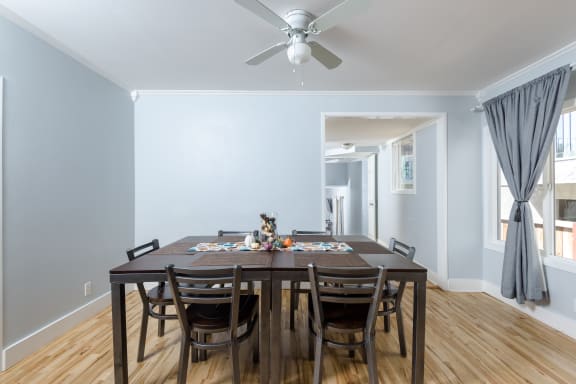 a dining room with a table and chairs and a ceiling fan