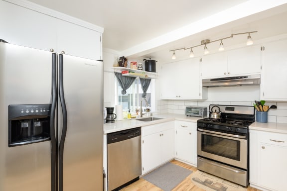 a kitchen with stainless steel appliances and white cabinets