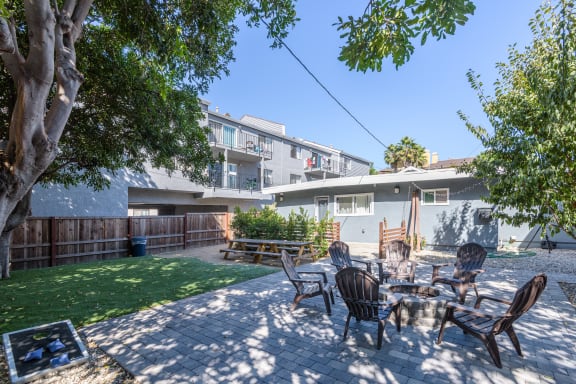 a backyard with a table and chairs and a tree