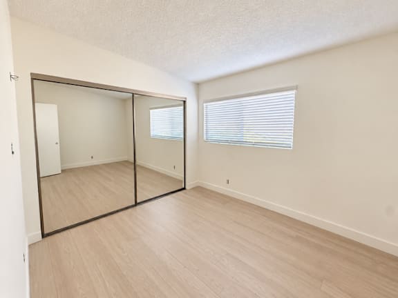 A room with a sliding door and a window with blinds.