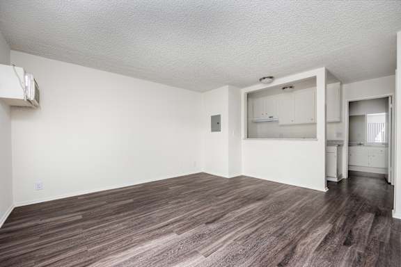 an empty living room with white walls and wood flooring