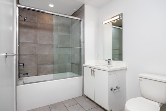 a bathroom with a shower and a sink and a toilet