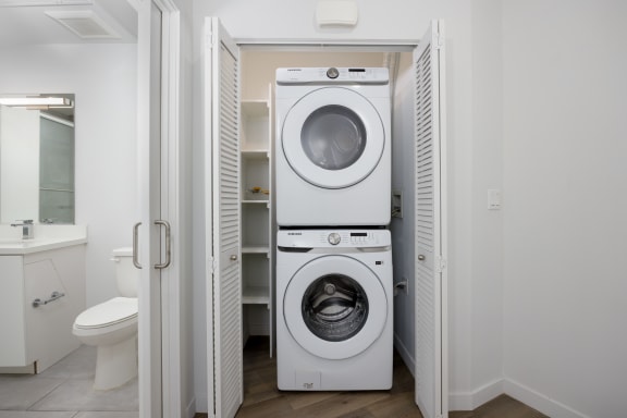 a white washer and dryer in a white laundry room