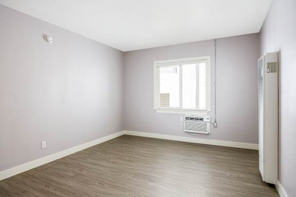 an empty room with white walls and a window
