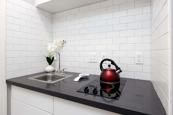 a kitchen with a kettle on the stove and a sink