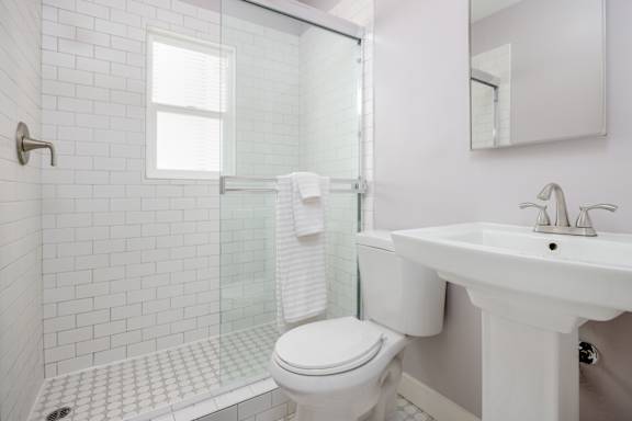 a white bathroom with a toilet and a sink