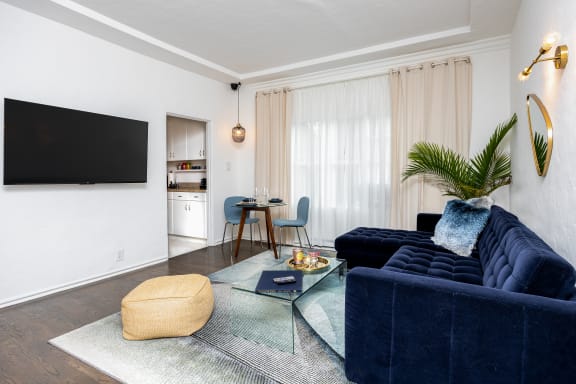 a living room with a blue couch and a tv