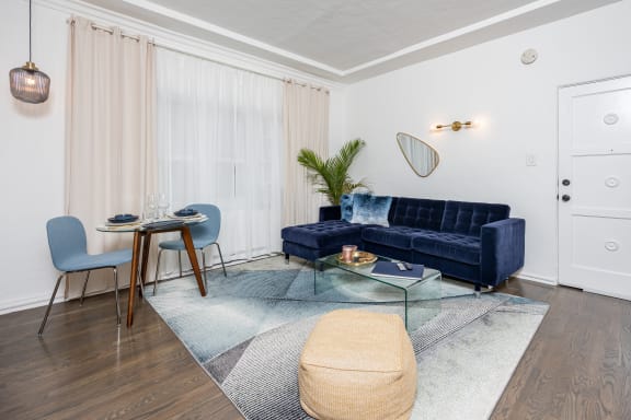 a living room with a blue couch and a glass coffee table