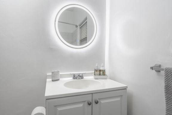 a white bathroom with a sink and a mirror