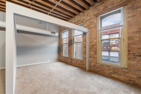 an empty room with brick walls and a large window