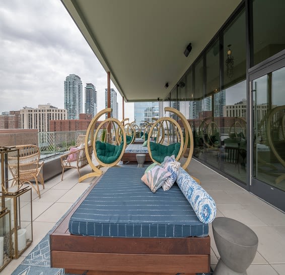 a bed on a balcony with a view of the city