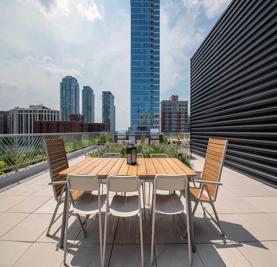 a communal terrace with a table and chairs on a rooftop