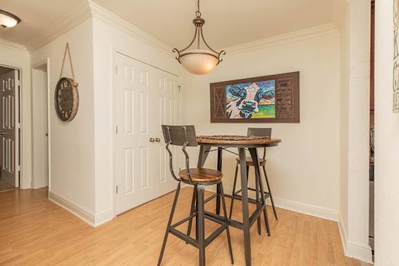 A dining room with a wooden table and chairs. at The Cove at State Street Apartments, Louisiana