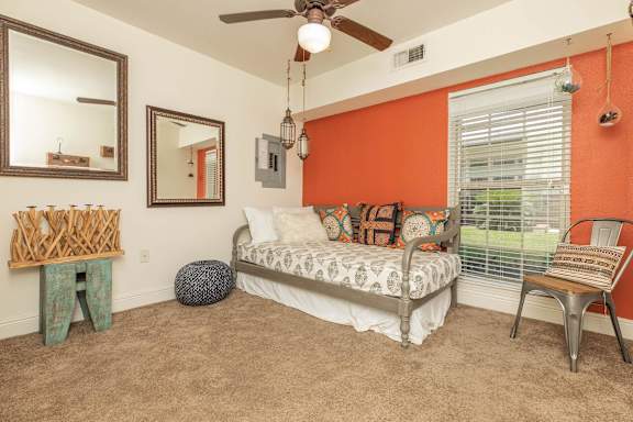 A bedroom with a bed, chair, and mirror. at The Cove at State Street Apartments, Louisiana