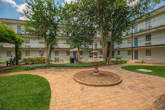 A courtyard with a fountain in the middle of it. at The Cove at State Street Apartments, Baton Rouge, Louisiana