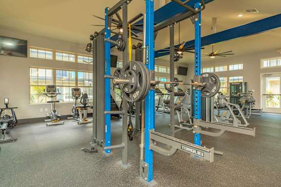 A gym with a weightlifting rack and other equipment. at The Cove at State Street Apartments, Louisiana