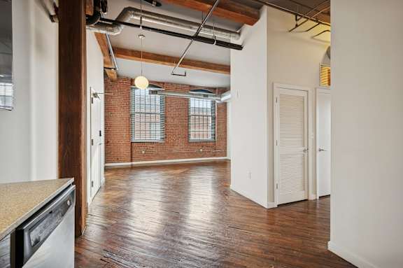 A room with wooden floors and a brick wall.