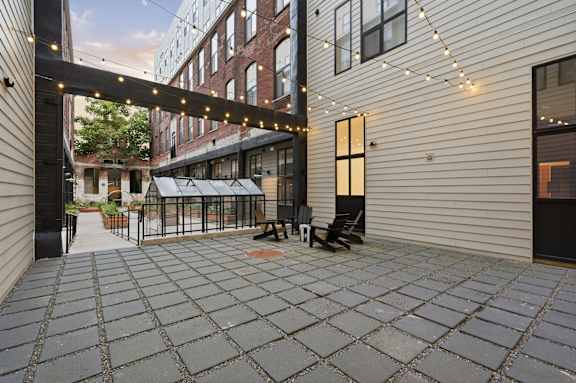 A patio with a table and chairs is surrounded by a brick building.