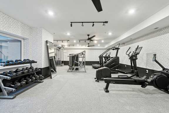 A spacious gym with a variety of equipment including treadmills, weights, and exercise machines.