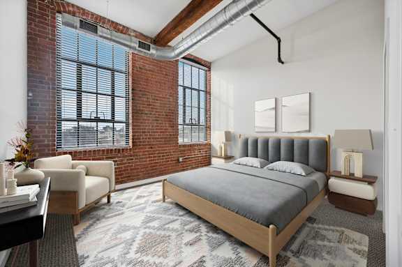 A bedroom with a large bed and a chair by the window.