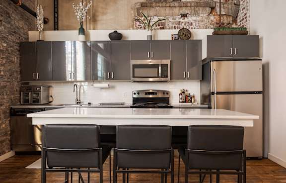 A kitchen with a white table and black chairs.
