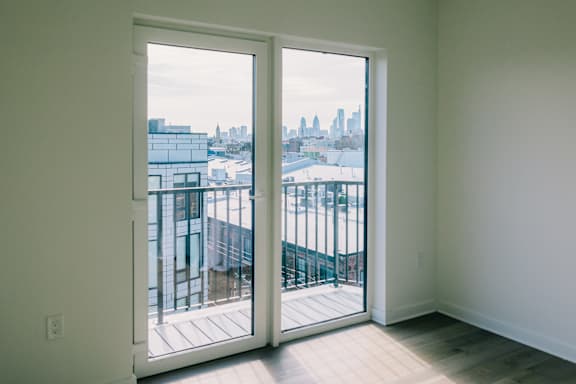 A view of a cityscape is visible through a large glass door.