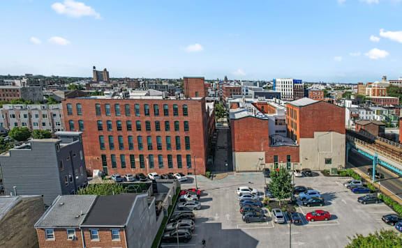 A parking lot with cars and a large building in the background.