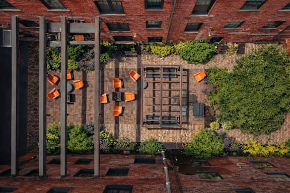 An overhead view of red brick building courtyard with orange chairs