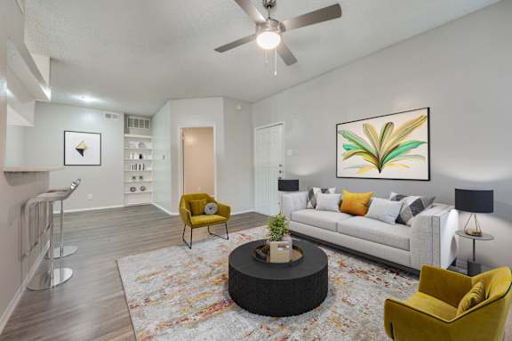 a living room with a couch and a ceiling fan