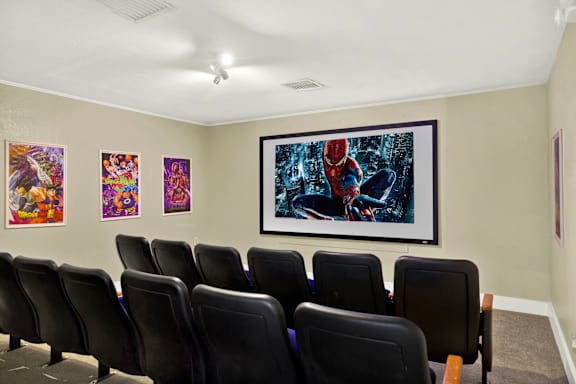 A room with a wall of posters and a row of chairs.