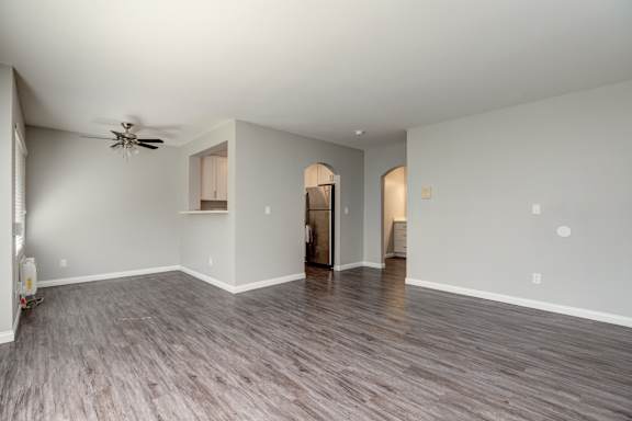 a living room with a ceiling fan and a hard wood floor