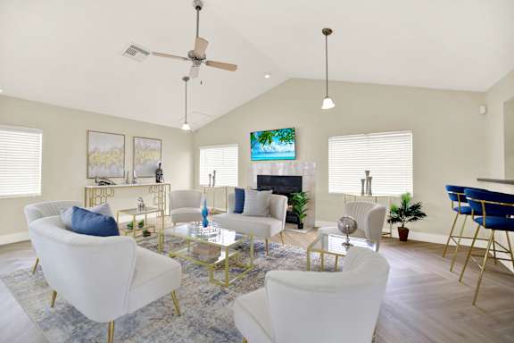 A living room with white furniture and a flat screen TV mounted on the wall. at Village Park, Orlando