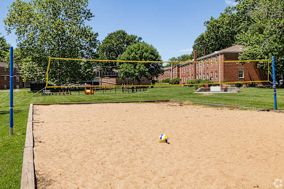 a volleyball court in front of a brick building with a volleyball
