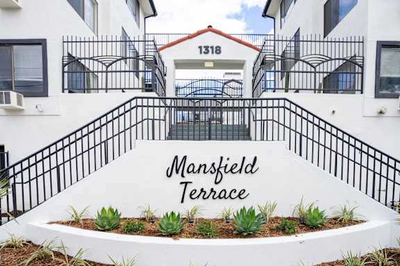 the entrance to the terrace building with the entrance sign to the building
