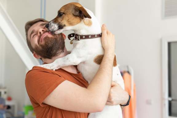 A man is holding a dog in his arms.