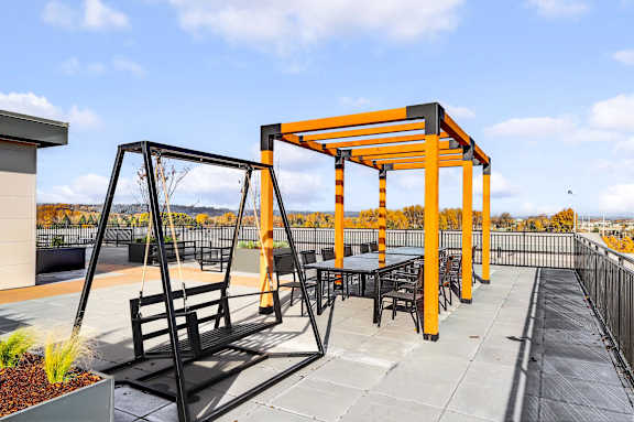 A black and orange swing set on a patio.