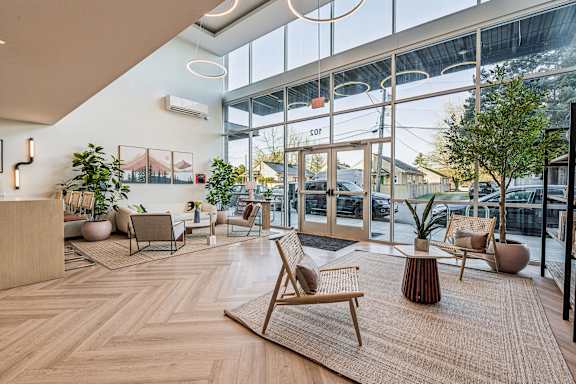 A modern waiting area with wooden floors and furniture.