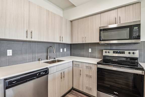 A modern kitchen with a stainless steel dishwasher and oven.