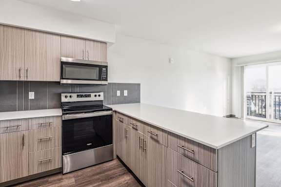 A kitchen with wooden cabinets and a stainless steel oven.