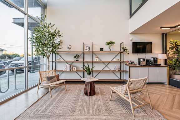 A living room with a brown rug and wooden furniture.