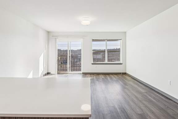 A room with a large window and a wooden floor.